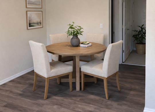 A dining room with a table and chairs.