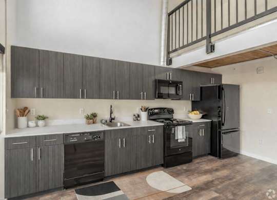 A modern kitchen with dark wood cabinets and stainless steel appliances.
