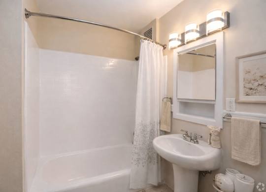 A white bathroom with a white sink and a white bathtub.