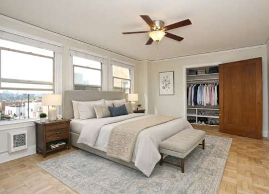 A bedroom with a large bed and a ceiling fan.