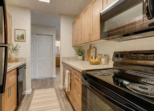 A kitchen with black appliances and wooden cabinets.