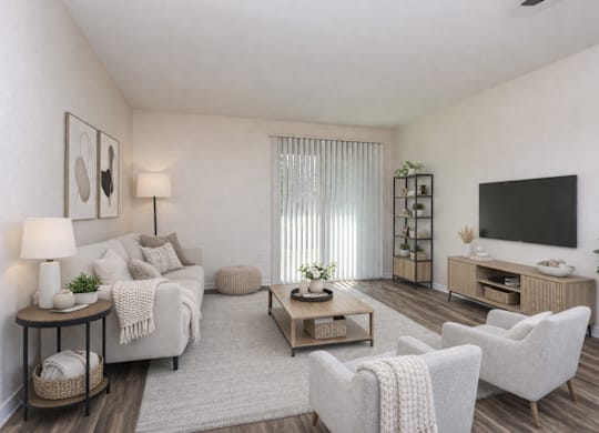 A living room with a white couch, a wooden coffee table, and a flat-screen TV mounted on the wall.