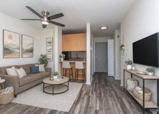 A living room with a couch, a coffee table, and a ceiling fan.