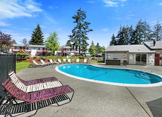 Large Pool with Lounge Chairs and Trees in the Background at Pinewood Square Apartment Homes, Washington, 98087