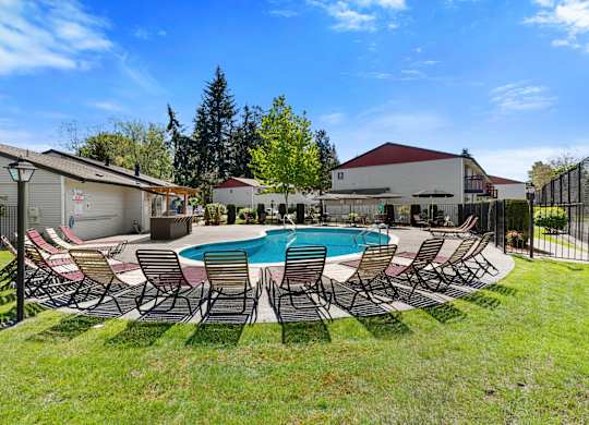 Cool Blue Swimming pool with Lounge Chairs and Grassy Area at Pinewood Square Apartment Homes, Lynnwood