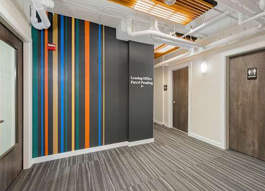 Corridor with Wall Art with a white lettering on it at Sir Gallahad Apartment Homes, Bellevue, Washington 98004