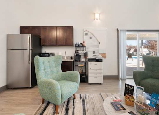 A kitchen with a refrigerator, a chair, and a dining table at Lakes Edge Apartments, Greensboro