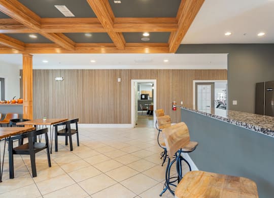 A kitchen with a bar area and a dining table. at Stone Gate Apartments, Spring Lake