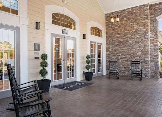A building with a stone wall and a glass door. at Stone Gate Apartments, Apartments, Spring Lake, NC