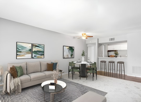 a living room with a couch a table and a chair and a kitchen in the background  at Lakes Edge Apartments, Greensboro, North Carolina