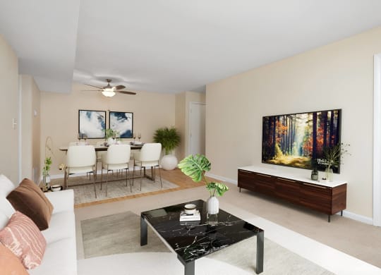 a living room with a couch and a table and a television at West Pointe Apartments in Burlington, NC