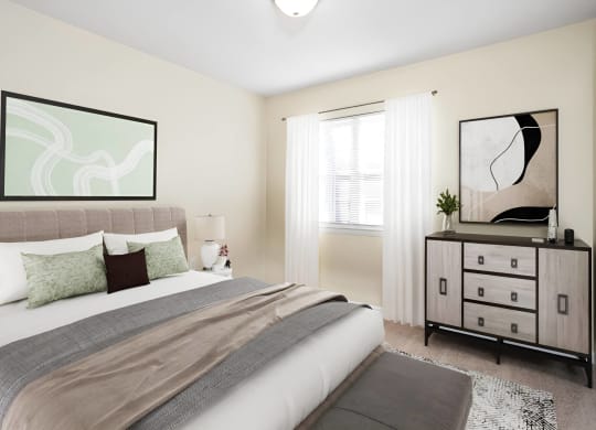a bedroom with a bed and a dresser at West Pointe Apartments in Burlington, NC