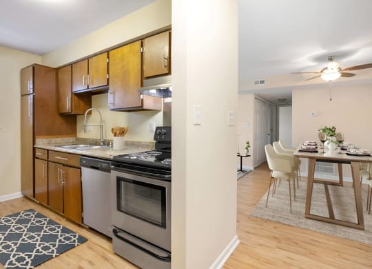 a kitchen with stainless steel appliances and a dining room table at West Pointe Apartments in Burlington, NC