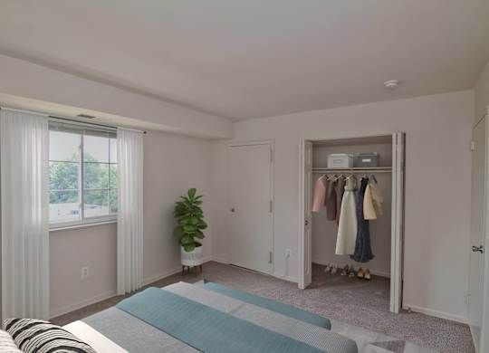 A bedroom with a bed, a window with curtains, a plant, and a closet with clothes.