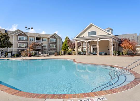A swimming pool in front of a building with a sign that says 25 FT 09M. at Stone Gate Apartments, Spring Lake, NC, 28390