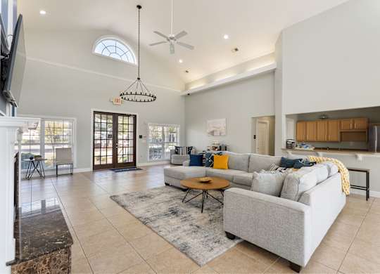 A living room with a grey couch and a rug. at Village on the Lake Apartments, Spring Lake, NC, 28390