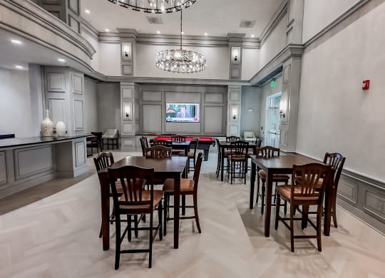a dining room with tables and chairs and a chandelier at The Mark at Dulles Station, Herndon