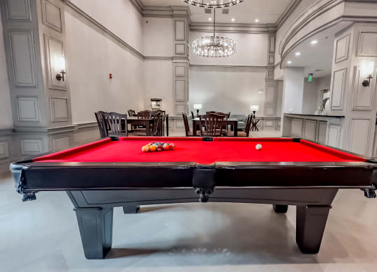 a red pool table in a large game room with a billiards at The Mark at Dulles Station, Herndon