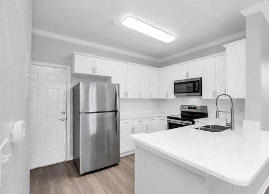 a kitchen with white cabinets and stainless steel appliances at Northlake Park, Florida,32827