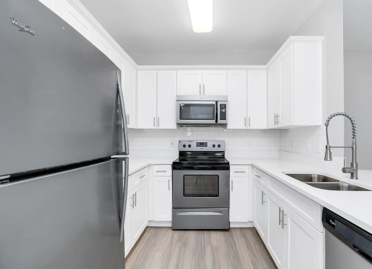 a kitchen with white cabinets and stainless steel appliances at Northlake Park, Orlando, 32827