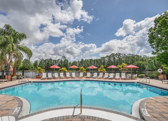 a resort style pool with lounge chairs and umbrellas at Northlake Park, Orlando, 32827