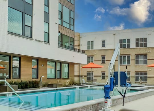 our apartments have a pool and a large building with umbrellas