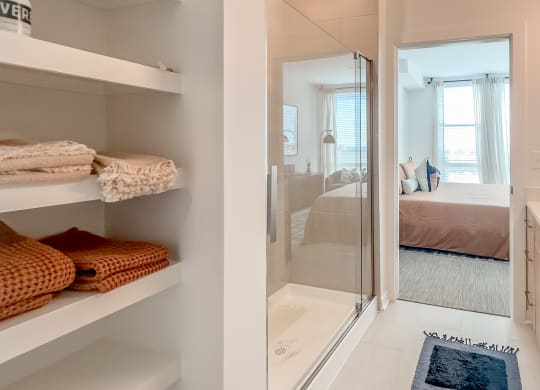 a bathroom with a shower and a sink and a bed