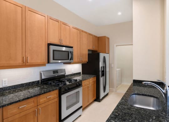 Kitchen with black appliances at The Mark at Dulles Station, Herndon