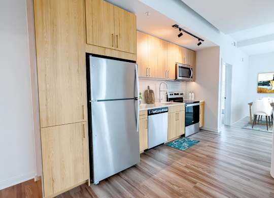 A kitchen with wooden cabinets and a stainless steel refrigerator.at Makers Rise, Herndon, VA  