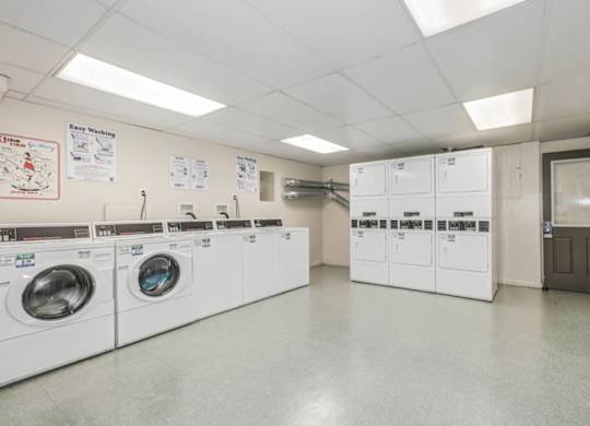 A laundry room with washing machines and a sign at Park Georgetown Apartments, Arlington, Virginia