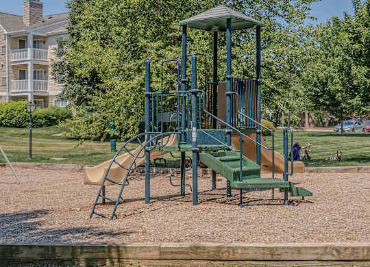 A playground with a green slide and a yellow slide.