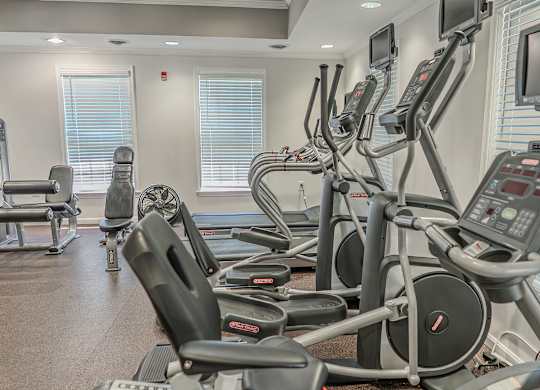 A gym with treadmills and elliptical machines.