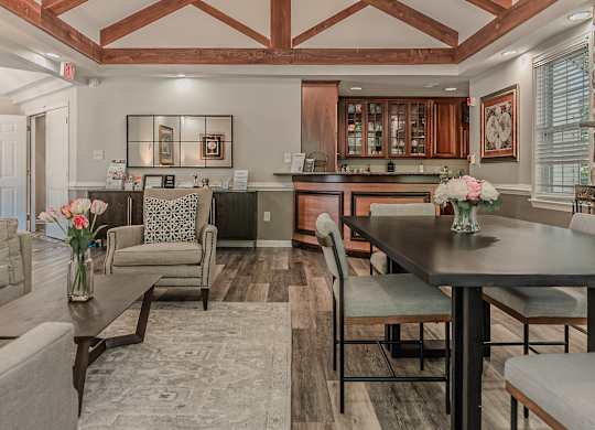 A well-lit, spacious kitchen and living room with a dining table and chairs.