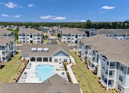 A large apartment complex with a swimming pool in the center.