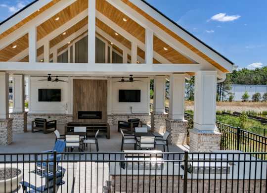 A covered patio area with a fireplace and seating area.