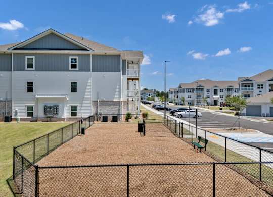 A large grey house with a black fence in front.