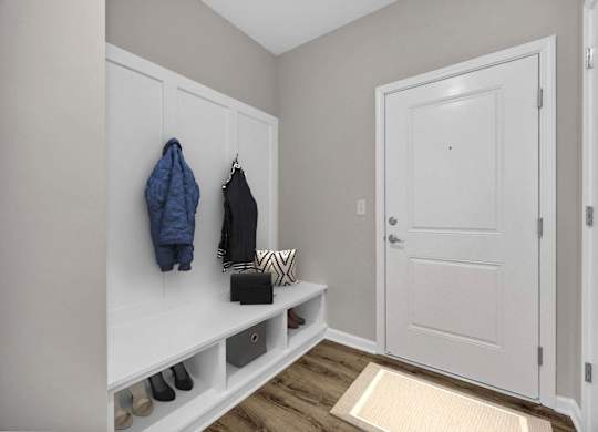 A hallway with a bench and coat hooks.