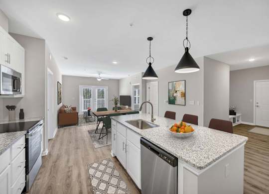 A modern kitchen with a granite countertop and stainless steel appliances.