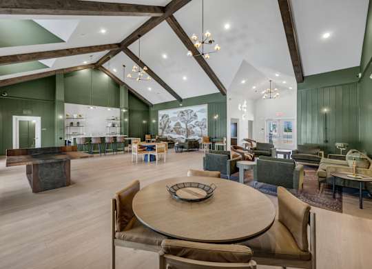 A large room with a wooden table surrounded by chairs.