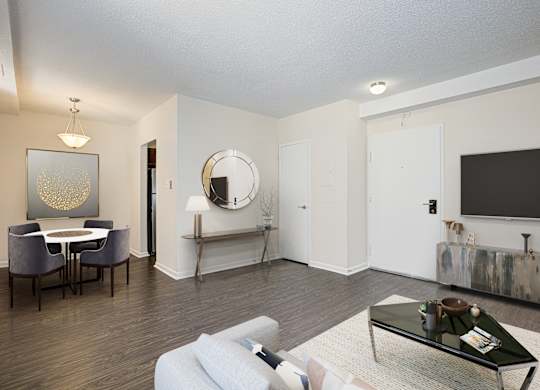 A living room with a white couch, a coffee table, and a mirror on the wall. at Columbia Uptown Apartments, Washington DC, 20009