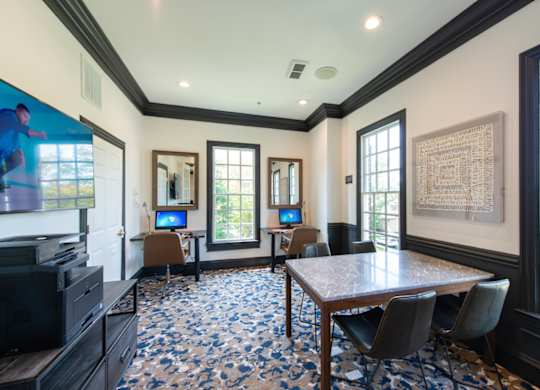 A room with a large table and chairs, a television, and a framed picture on the wall. at Fairfax Square Apartments, Virginia