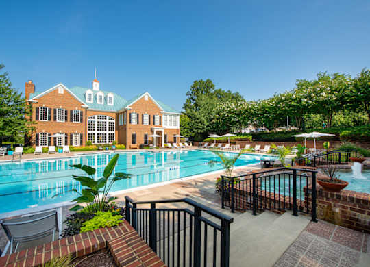 A large pool with a brick wall and a building behind it at Fairfax Square Apartments, Virginia, 22031