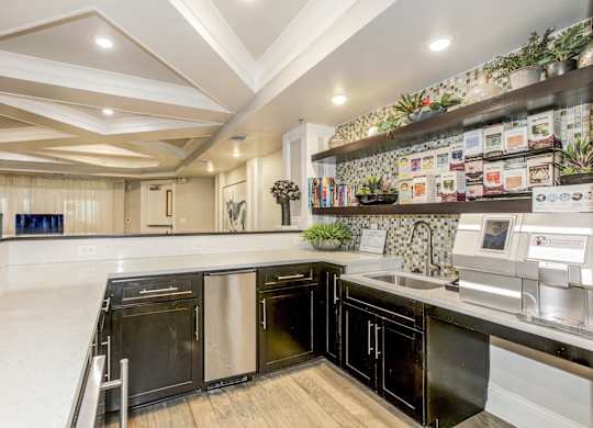 A modern kitchen with black appliances and wooden floors. at Kensington Place Apartments, Woodbridge, VA