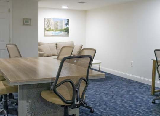 A conference room with a long table and chairs.