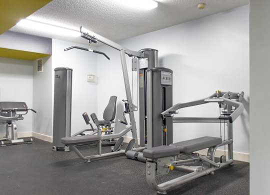 A gym with a weight machine and a bench.