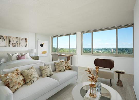 A living room with a white couch and a glass table.