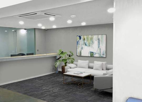 A modern office space with a glass wall, a white couch, and a painting on the wall.