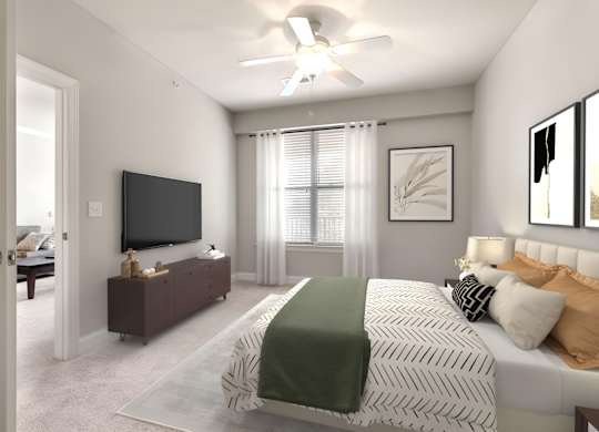 A bedroom with a bed, a television, and a ceiling fan at The Villagio Apartments, Fayetteville, 28303