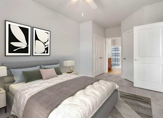 A bedroom with a large bed and two framed pictures on the wall at The Villagio Apartments, Fayetteville