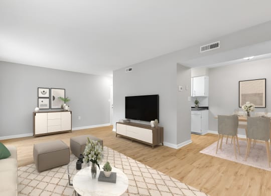 a living room with a table and chairs and a television at West Pointe Apartments in Burlington, NC
